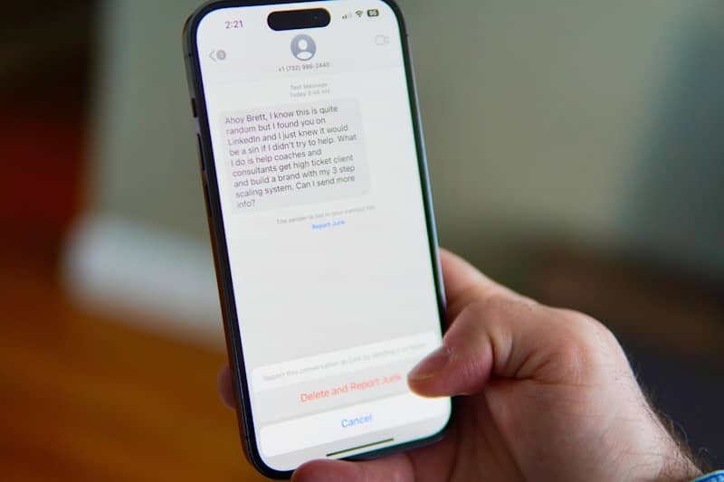 Hand holding a smartphone displaying a text message conversation.