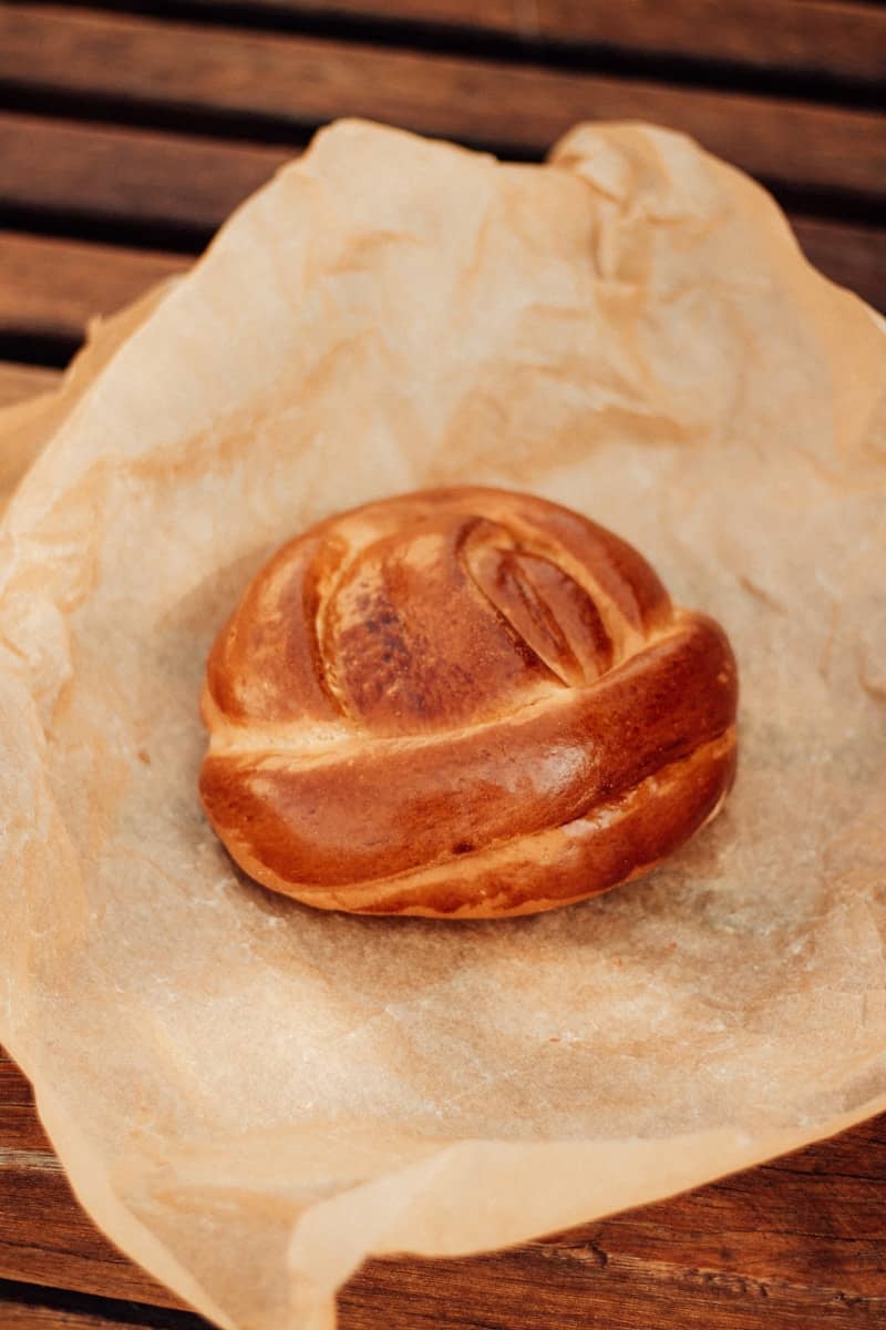 A golden brown braided pastry rests on parchment paper.