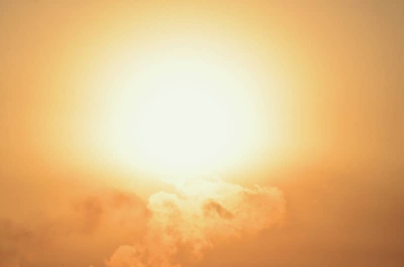 Bright sun shines through the clouds at dawn.