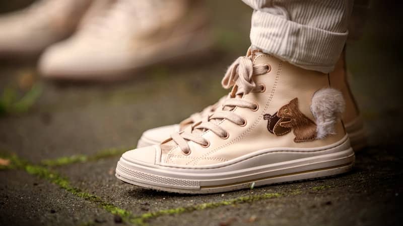 Cream-colored sneakers with adorable, furry embellishments.