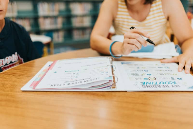 Homeschool mom with checklist in binder