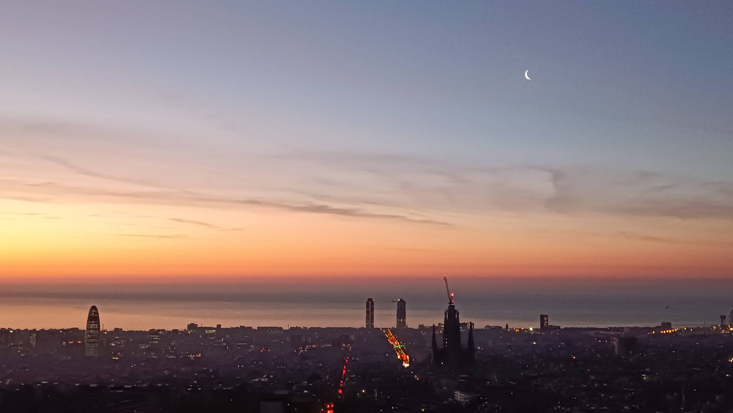 view of Barcelona at sunrise with the moon over the Sagrada Familia