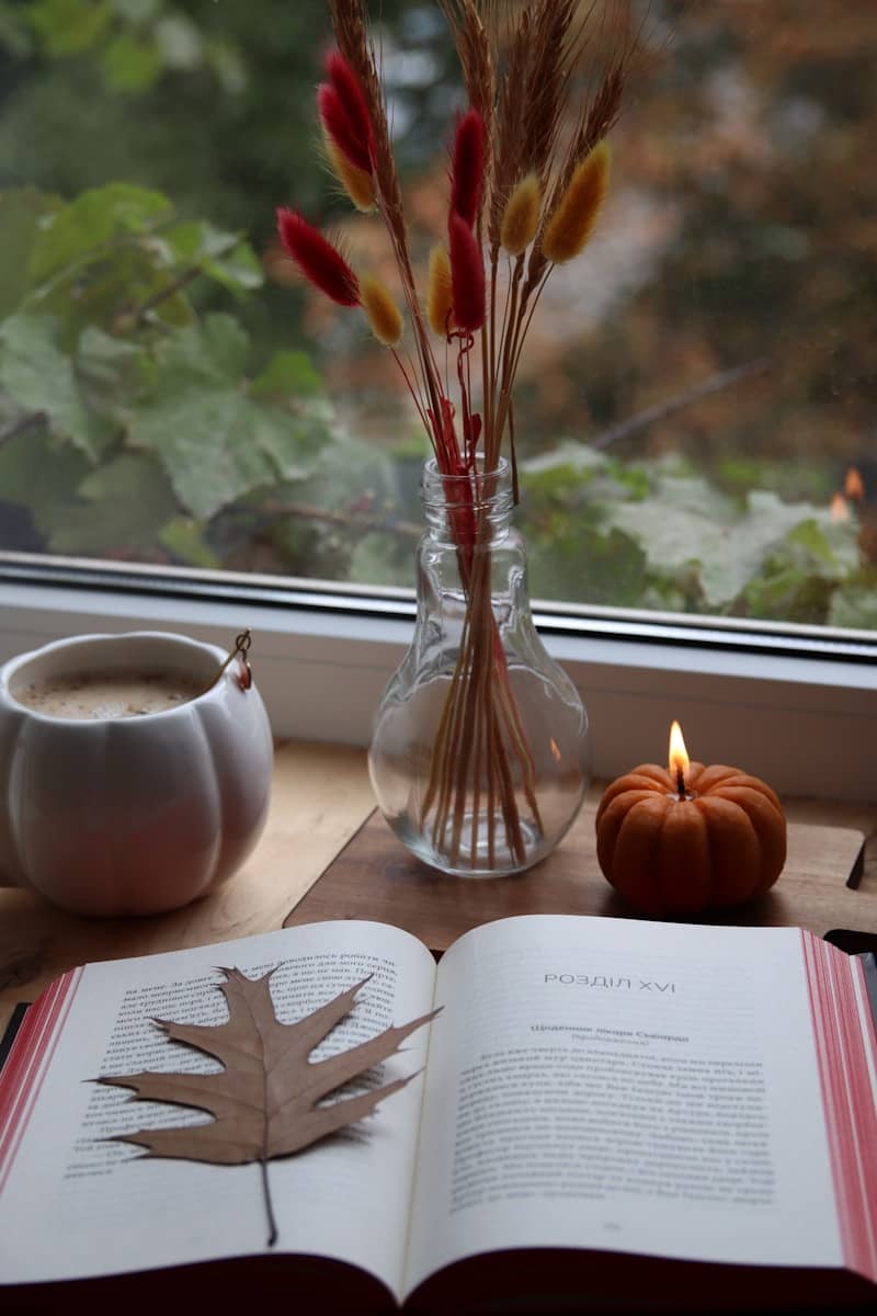 Autumnal still life with book, coffee, and candle.