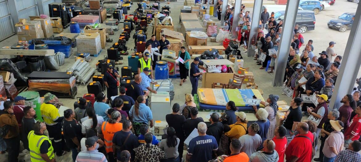 Customs officers working at Queen Salote Wharf in Nuku'alofa, Tonga, preparing items for auction amid controversy over stranded freight shipments from New Zealand being sold without proper notice to their owners.