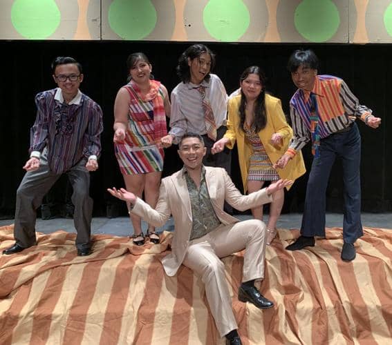 Students perform complex score that tracks three friends' lives backward through 20 years.