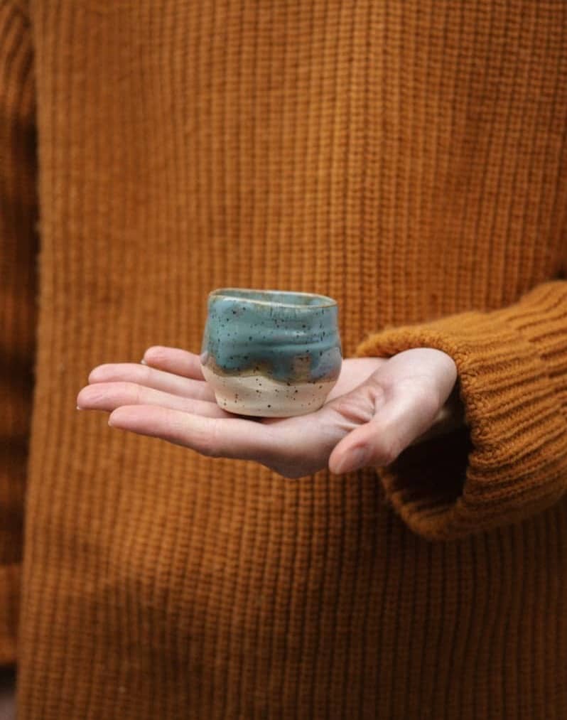 Woman holding ceramic object in hand