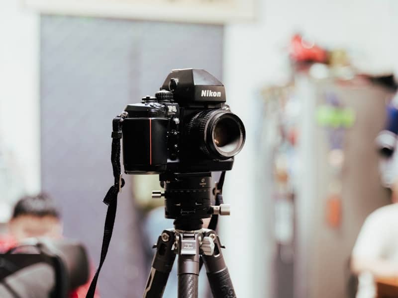 A black nikon camera on a tripod