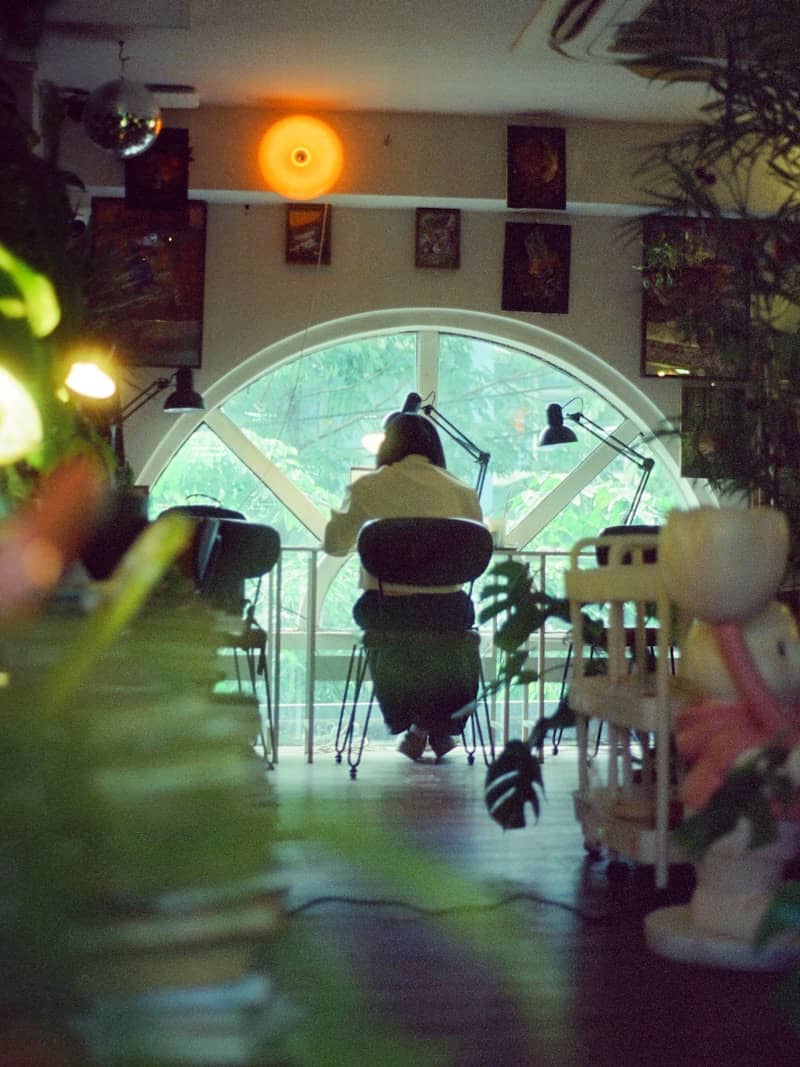 Person working at a desk by a large arched window.