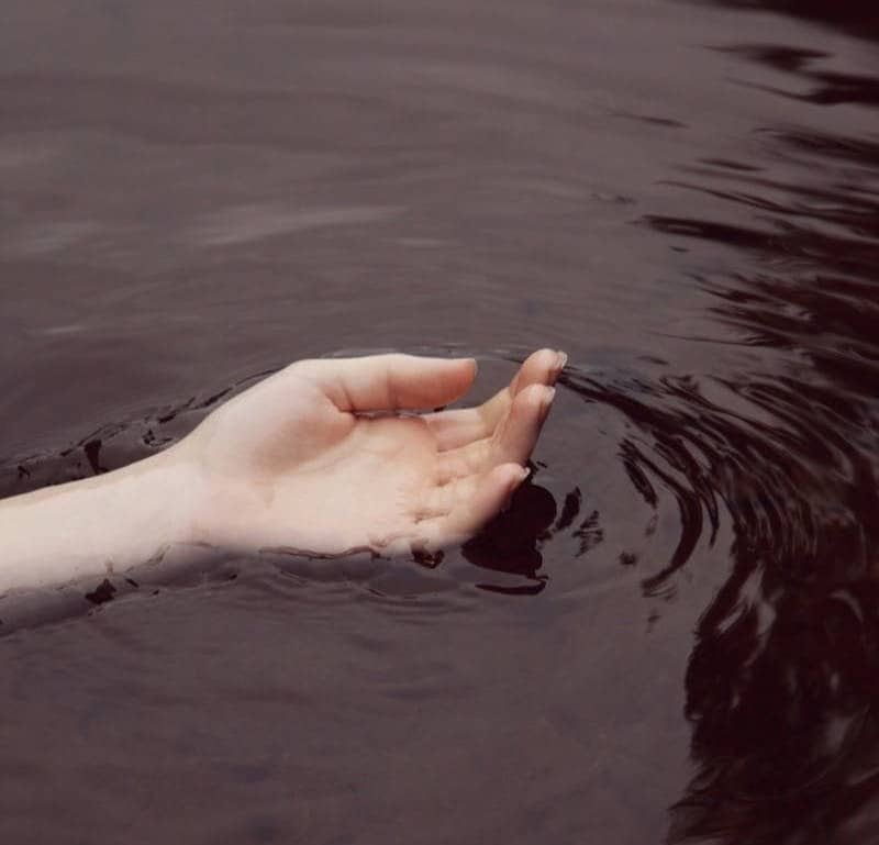 Woman’s hand floating in water 