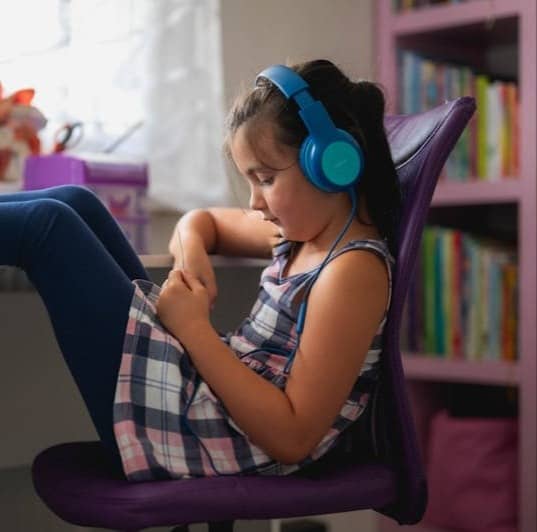 A little girl sitting in a chair with headphones on