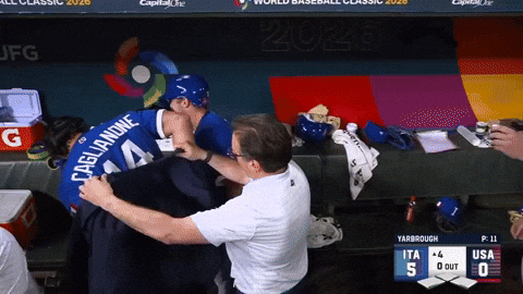 A GIF of the Italian team taking espresso shots in the dugout before hugging and kissing each other.