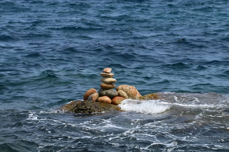 Stacked stones on a rock in the ocean