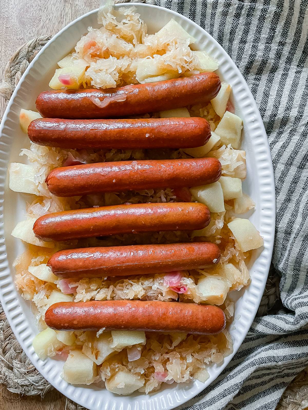 crockpot hot dogs with sauerkraut on a white serving platter