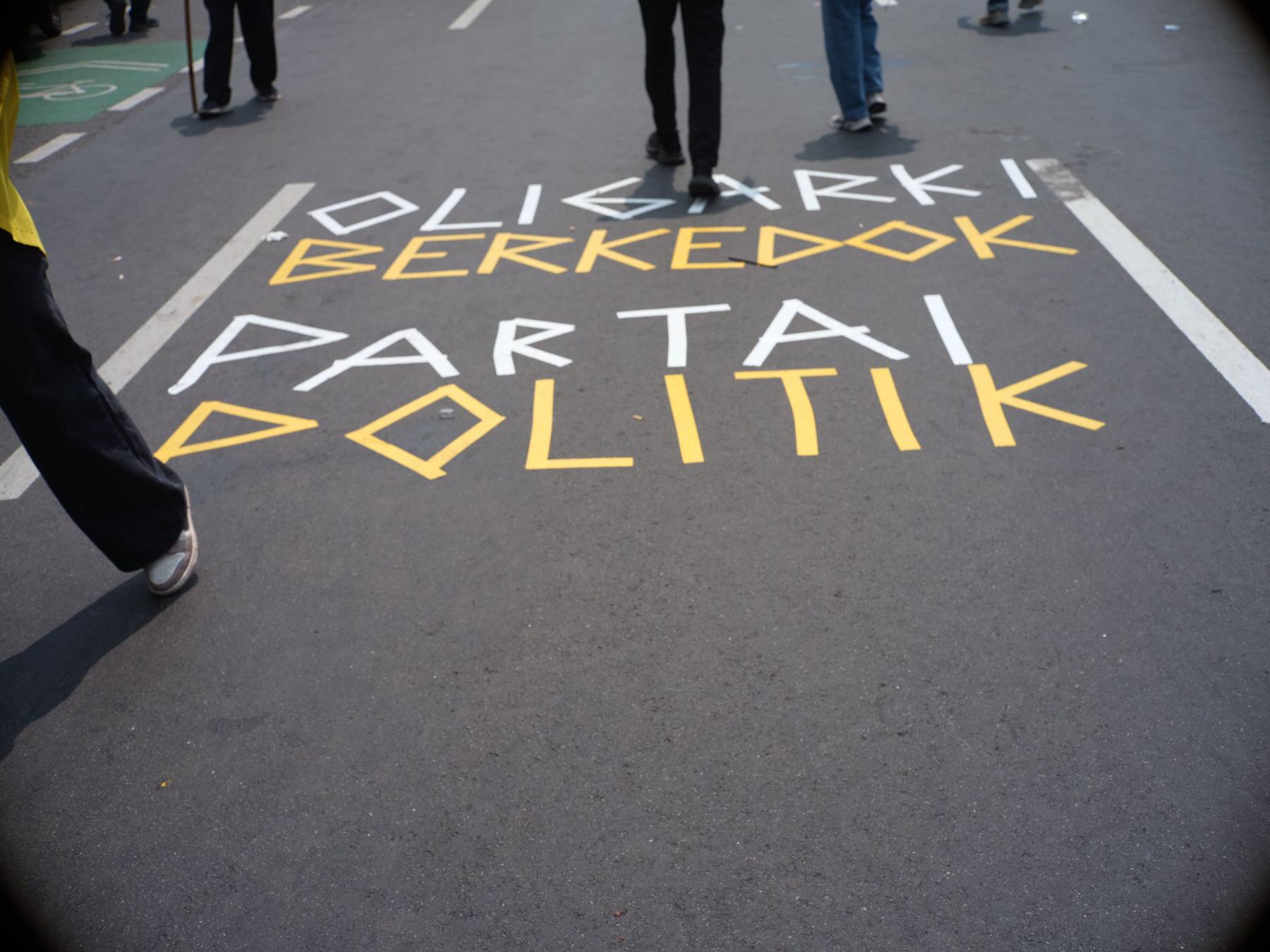 Teks protes "Oligarki Berkedok Partai Politik" dalam aksi Peringatan Darurat di jalan raya depan gedung DPR Senayan, Jakarta, 22 Agustus 2024.
