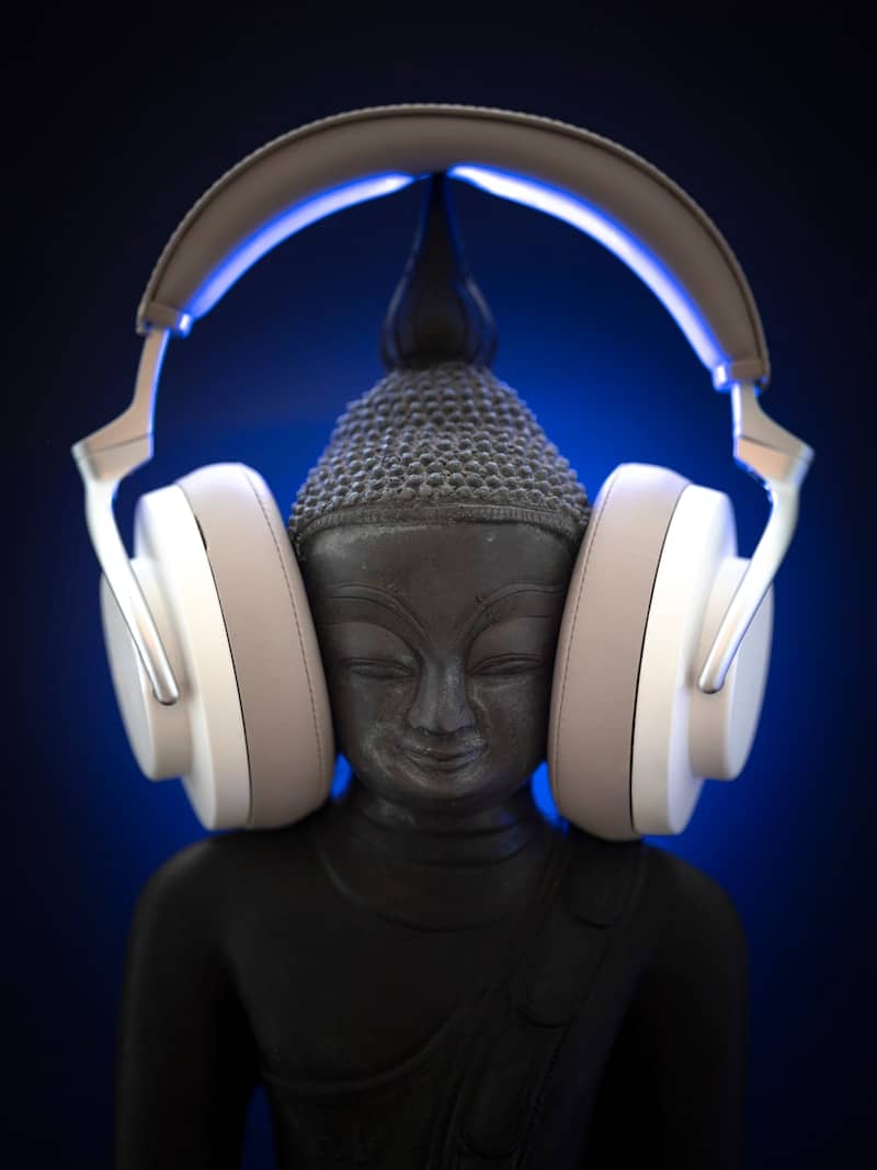 Buddha statue wearing modern headphones with blue light