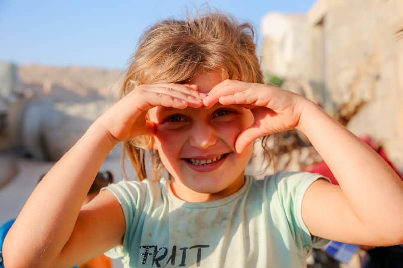 A little girl making a heart with her hands