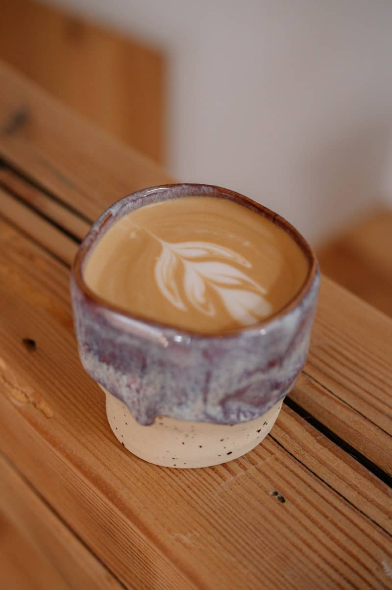 A latte with latte art in a unique ceramic cup