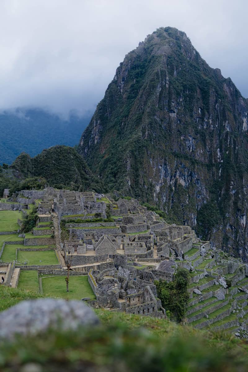 Ancient inca ruins on a mountainside under cloudy sky