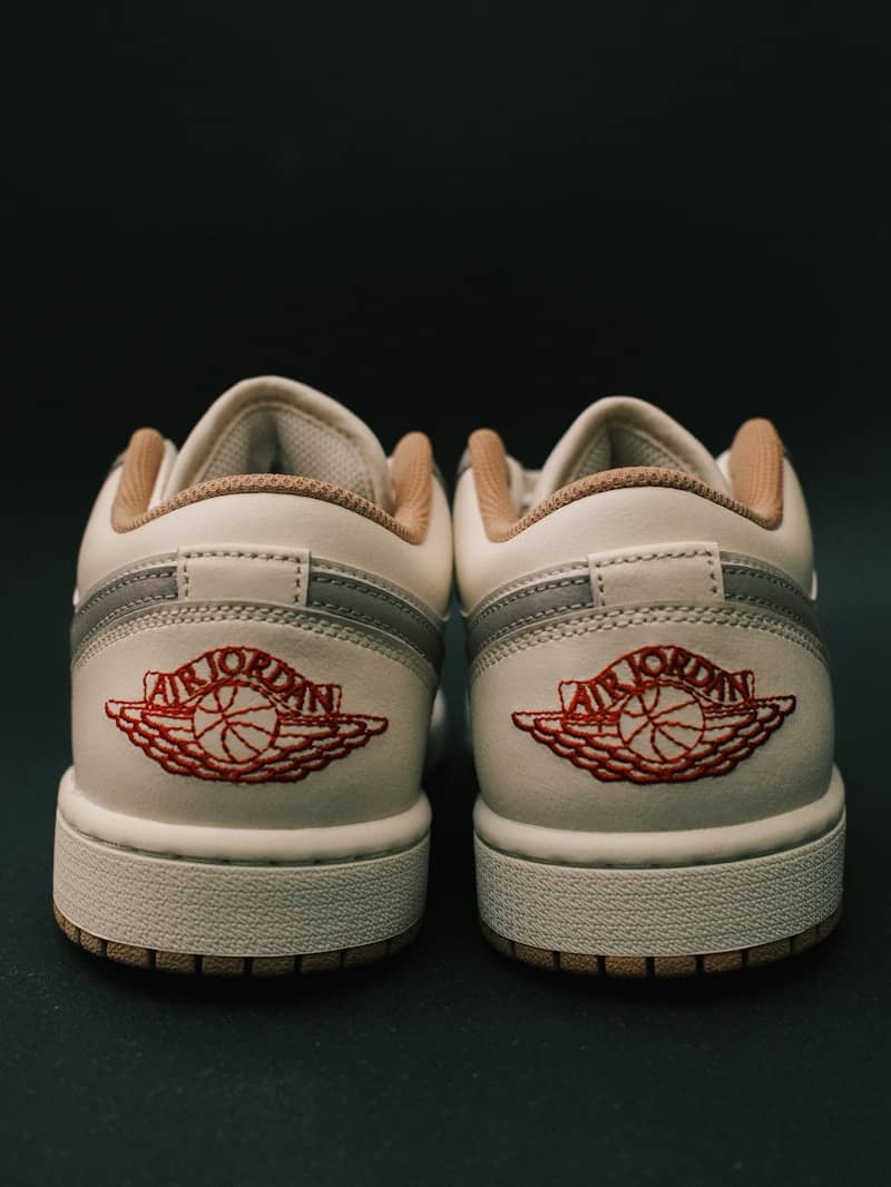 Pair of white air jordan sneakers on black background