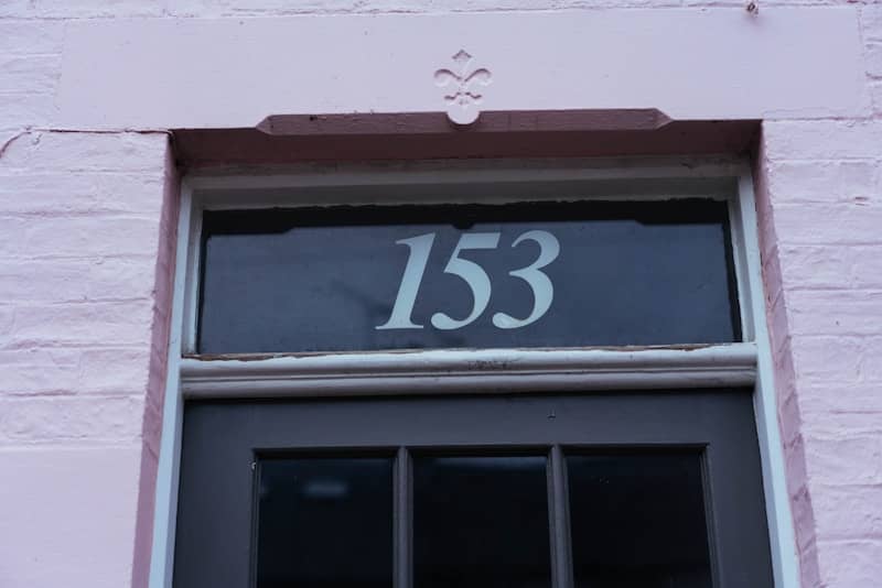 The number 153 is displayed above a dark door.