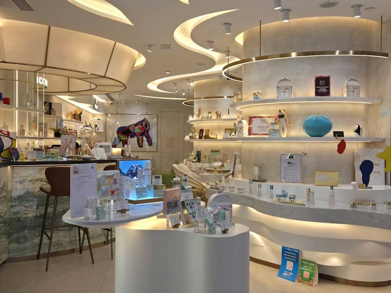 Skincare products displayed on curved white shelves and tables in a modern boutique