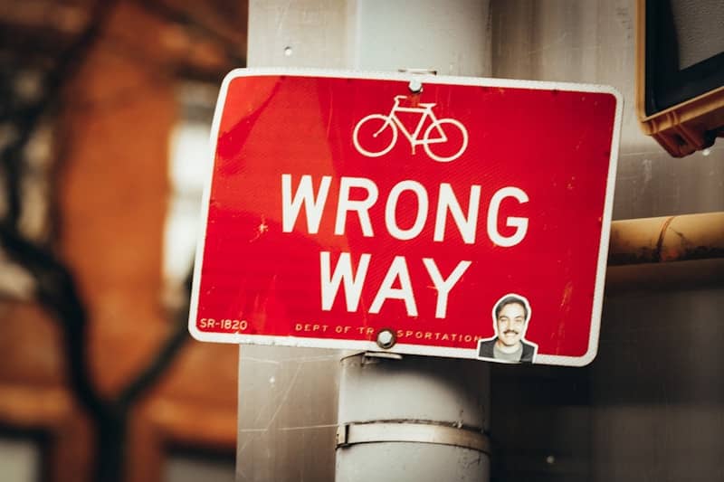 a red wrong way sign on a pole