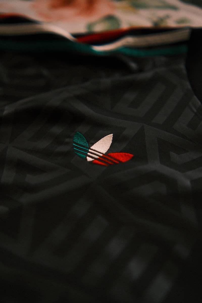 Adidas logo on dark patterned jersey with floral collar.