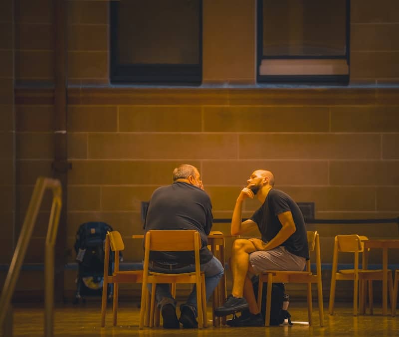 Two men sitting at a table talking