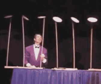 GIF of man spinning plates on top of sticks