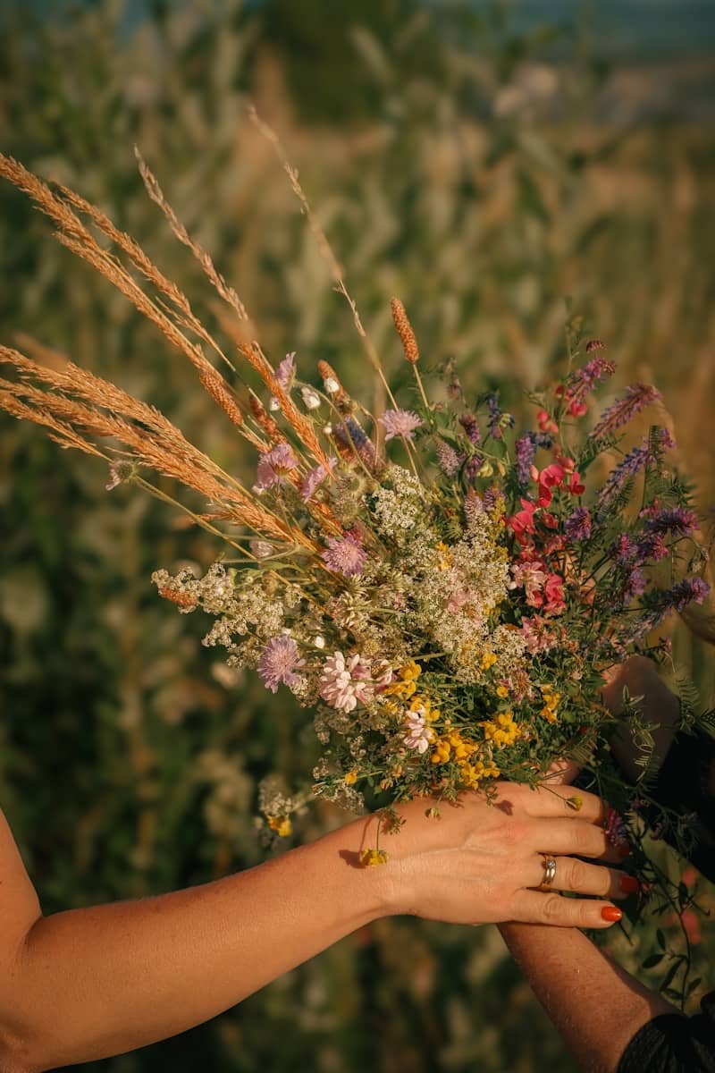 Hands hold a beautiful bouquet of wildflowers.