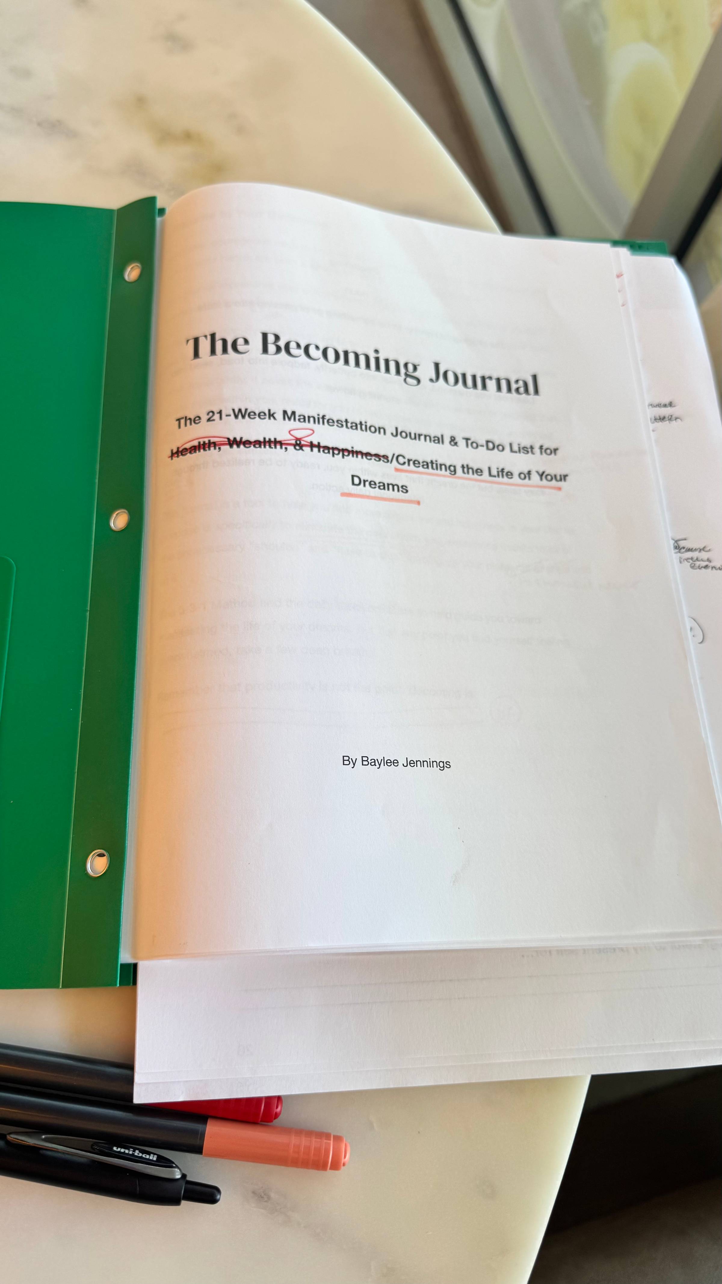 Printed out cover page of "The Becoming Journal" by Baylee Jennings with red ink pen editing