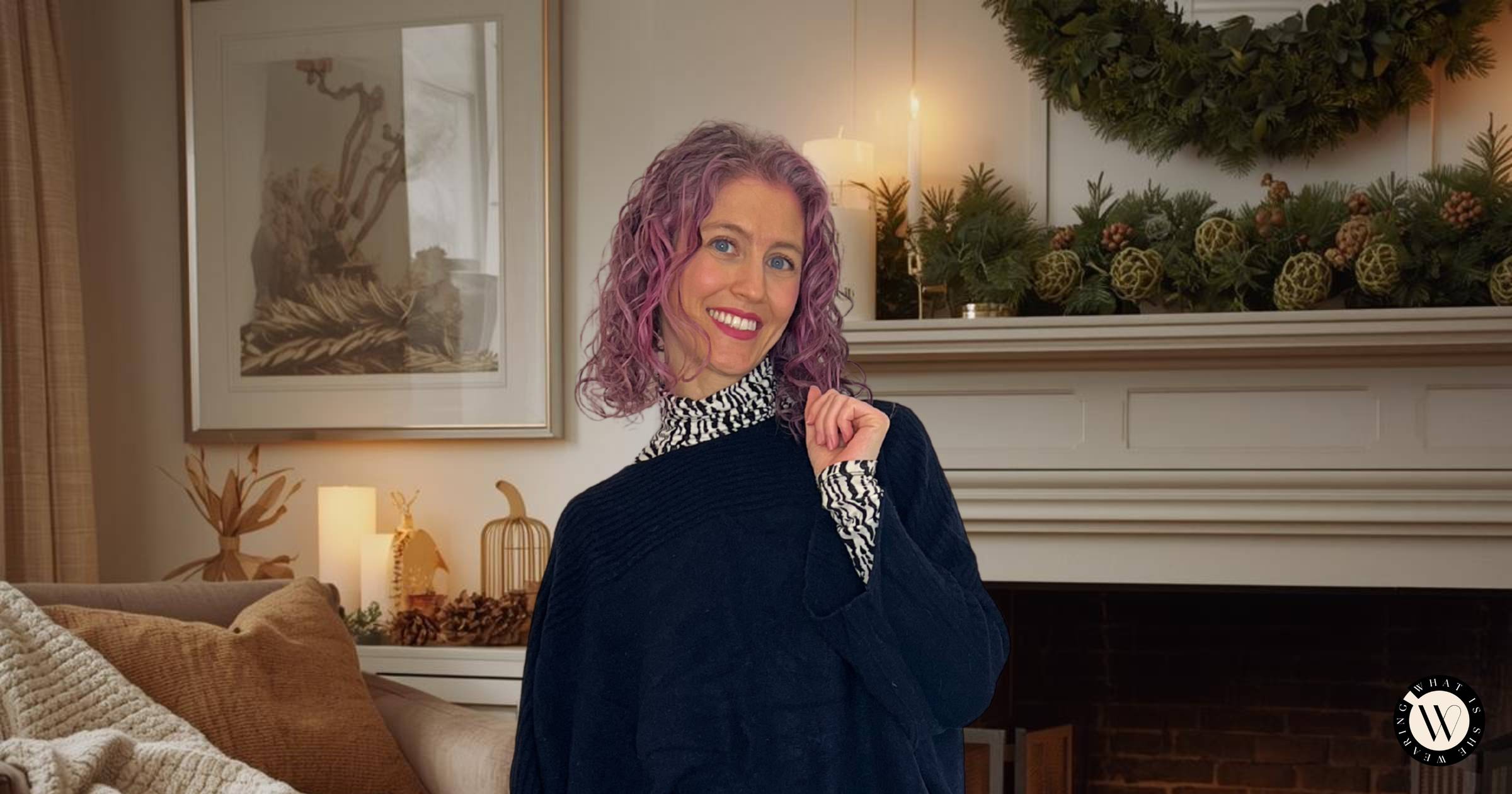 A woman wearing a cozy winter outfit at home, in front of a fireplace.