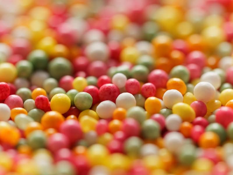 Colorful sprinkles are scattered in a close-up view.