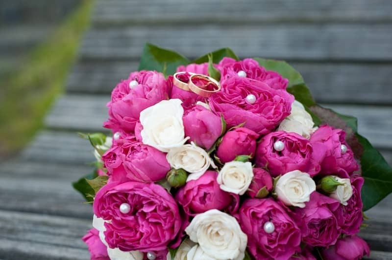 Wedding bouquet with rings atop the flowers.