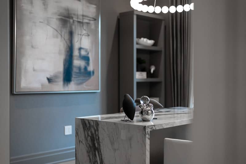 Modern office with marble desk and abstract art.
