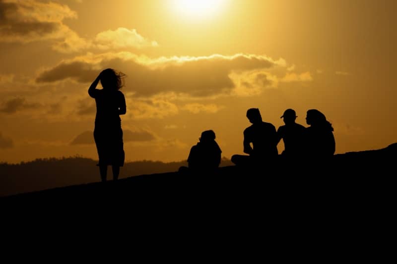 A group of people sitting on top of a hill