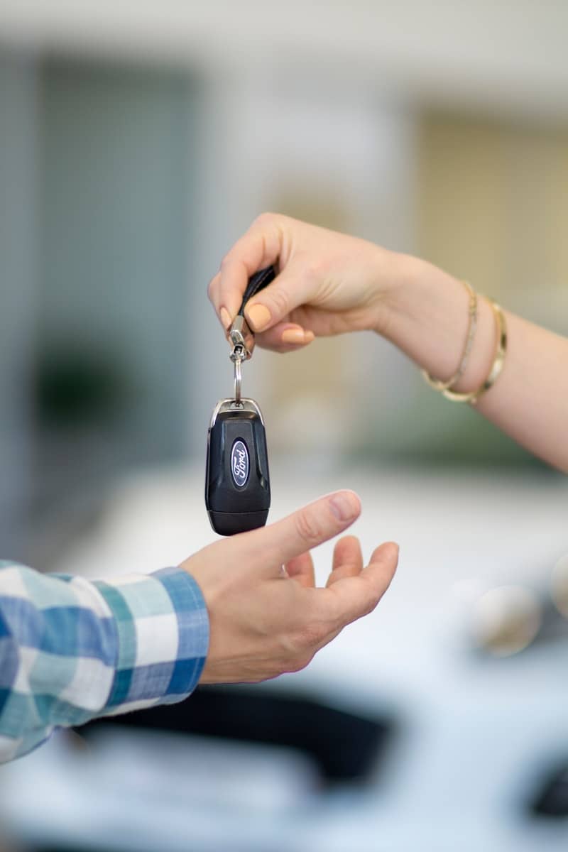 A person handing a car key to another person