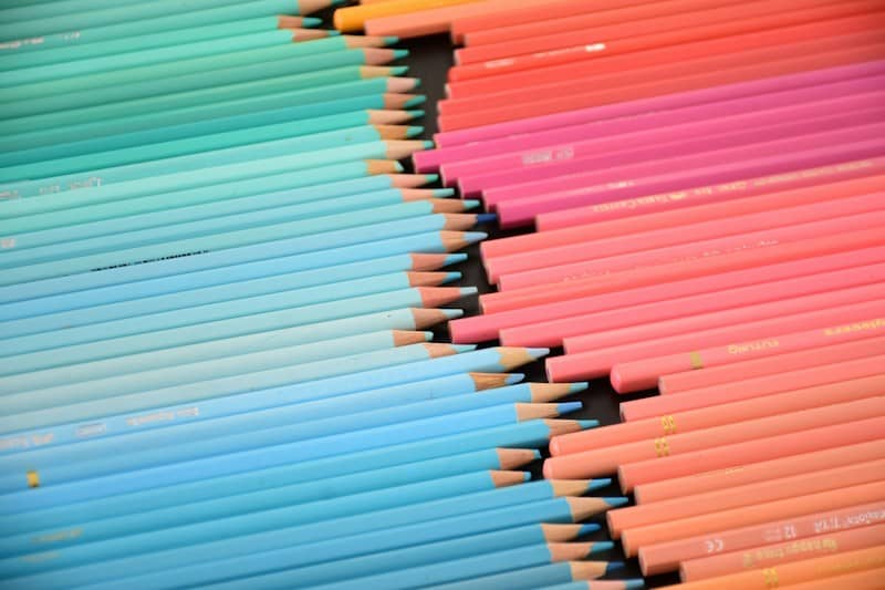 A collection of blue and pink colored pencils arranged in two converging rows