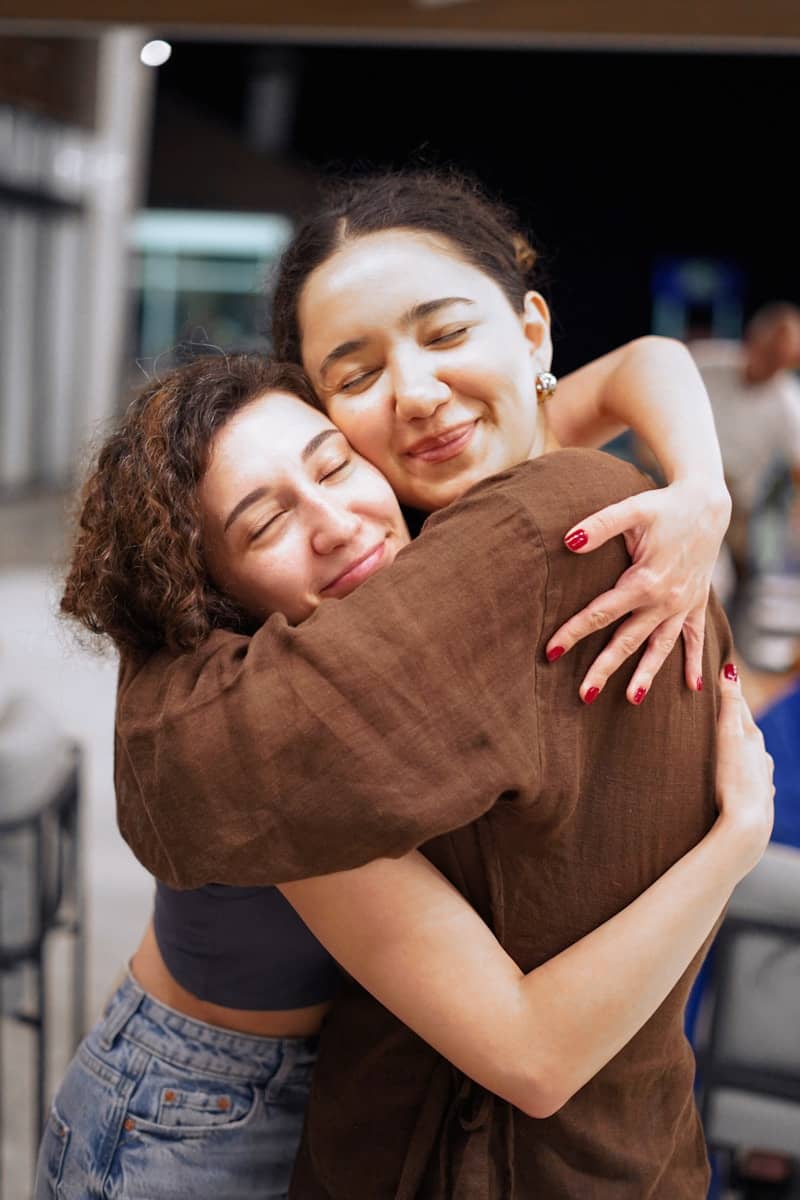 A couple of women hugging each other in a room