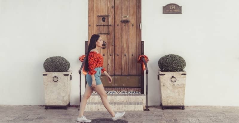 woman in red and black dress standing beside brown wooden door