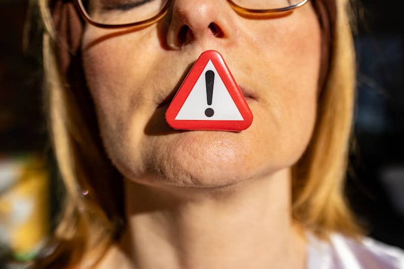 A woman with a red and white warning sign on her nose