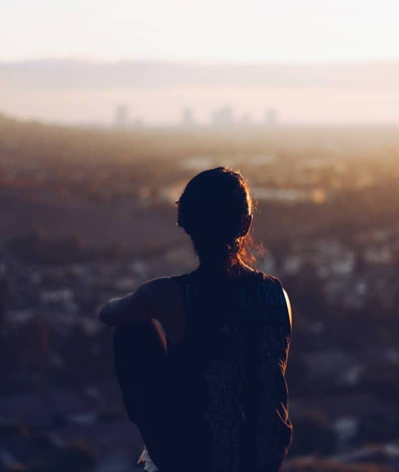 woman sitting on brown rock during daytime