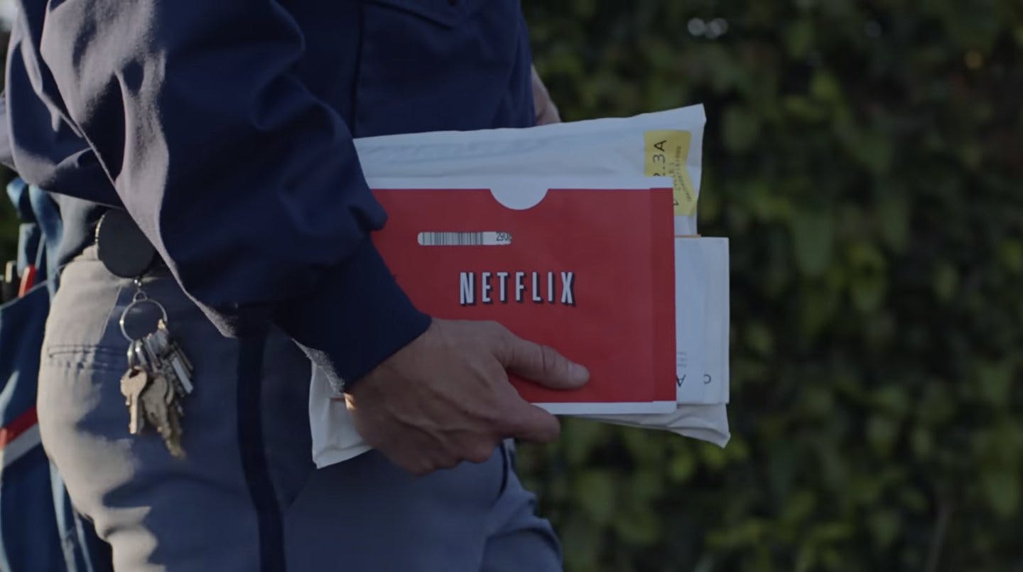 Post office worker carries Netflix pouch in right hand