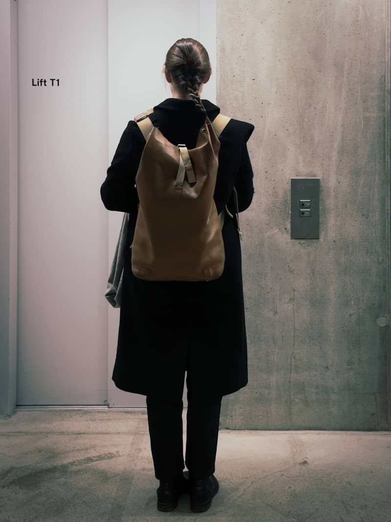 Woman with backpack waits for elevator