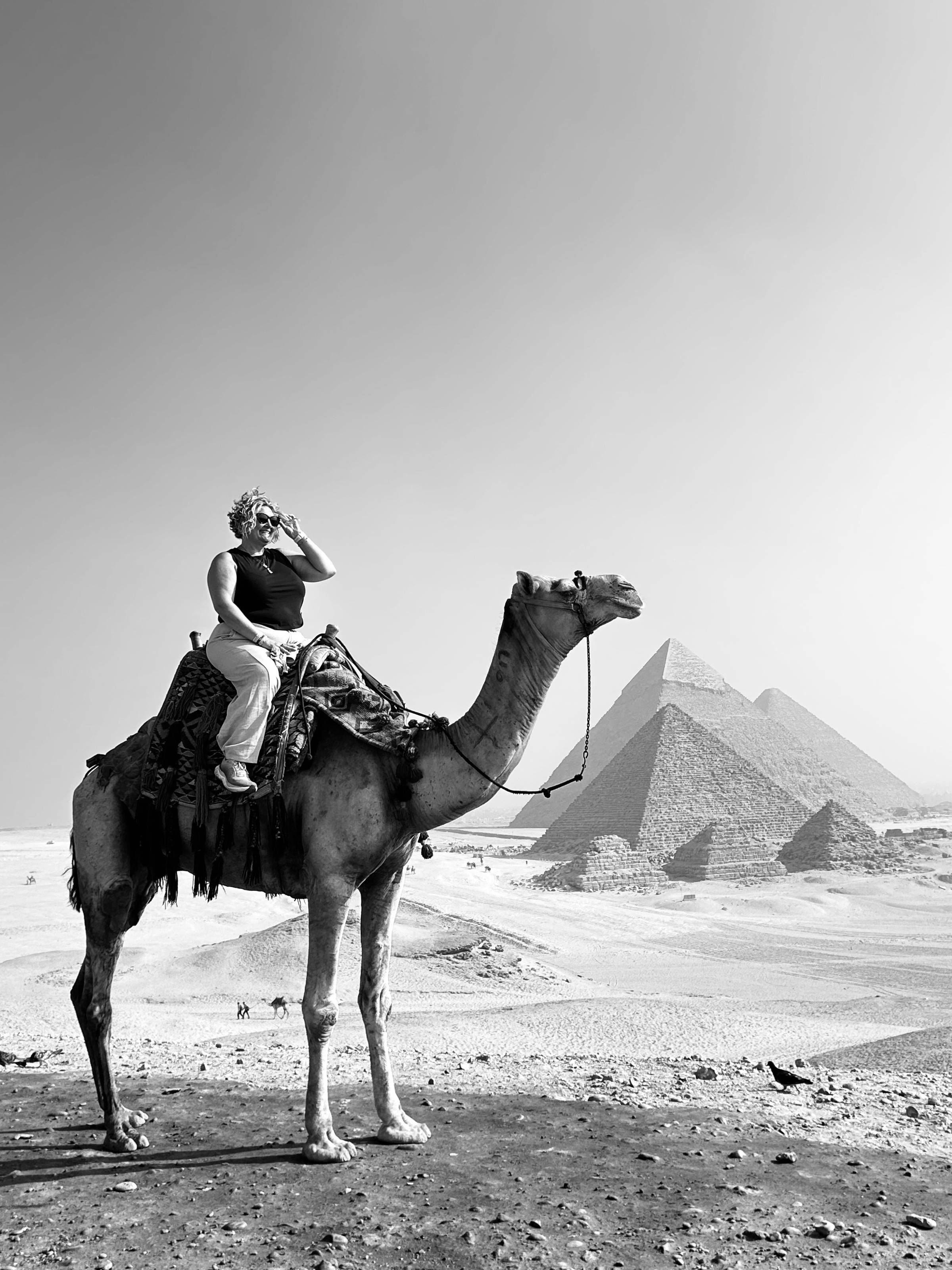 Jess Sato on a camel in front of the pyramids