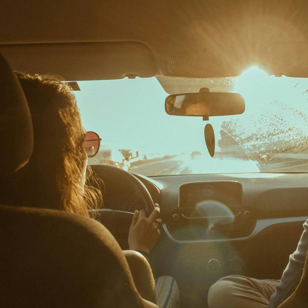 Woman driving with the sun glaring in her eyes