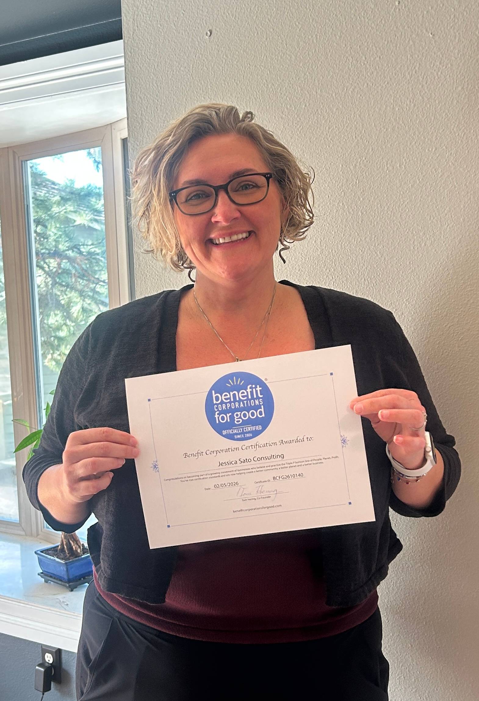 Jess Sato with a Benefit Corporation for Good Certificate