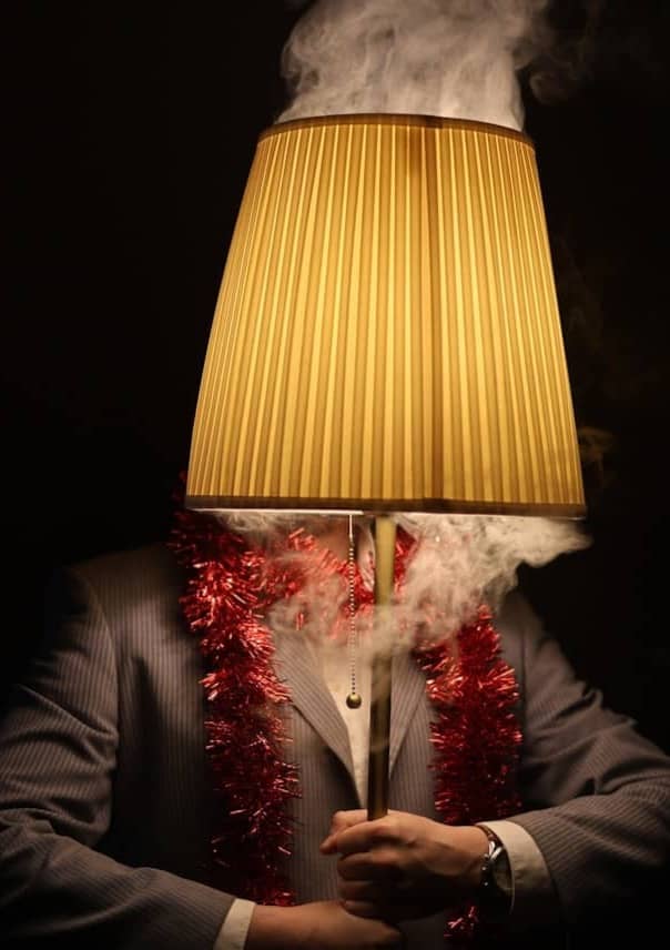 A man has a lampshade for a head.