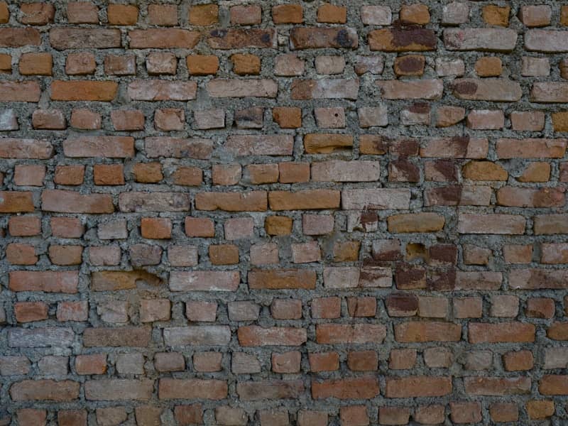 a brick wall with a clock on the side of it