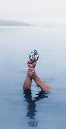 person underwater holding anchor scale model